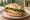 Panino con Cotoletta Milanese: an illustration of veal, egg and arugula on kaiser roll.