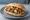 Panino con Gröstl: an illustration of pork, potato and onion on bread.