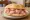 Panino con Mortadella Bologna IGP: an illustration of pork and mortadella on bread.
