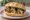 Panino con Sarde a Beccafico: an illustration of sardine, raisins, lemon and olive oil on kaiser roll.