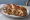 Philly Pretzel Cheesesteak: an illustration of beef, cheese and onion on pretzel roll.