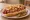 Phoenix Sonoran Hot Dog: an illustration of hot dog, bacon, beans, tomato and more on telera roll.
