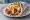 Pita Gyros me Mustarda: an illustration of pork, tomato, onion, tzatziki and more on pita.