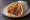 Pita Gyros me Tyrokafteri: an illustration of pork, tomato, onion and potato on pita.