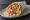 Pita me Feta: an illustration of feta, tomato, onion, potato and more on pita.