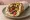 Pita me Lachanika: an illustration of tomato, onion and lettuce on pita.