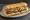 Po' Boy (Hot Sausage): an illustration of pork, sausage, lettuce, tomato and more on baguette.