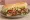 Po' Boy (Roast Beef): an illustration of beef, gravy, lettuce, tomato and more on baguette.