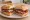 Politiko Sandwich: an illustration of beef, tomato, cheese and pickle on bread.
