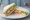 Prawn Salad Sandwich: an illustration of shrimp, mayonnaise, lettuce, cucumber and more on white bread.
