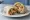 Qdoba Burrito: an illustration of rice, beans, cheese, cheese sauce and more on tortilla.