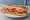 Quiznos Classic Italian: an illustration of salami, pepperoni, ham, capicola and more on hoagie roll.