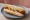 Red Hot: an illustration of pork, beef, mustard and onion on hot dog bun.