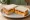 Red Leicester Sandwich: an illustration of butter and pickle on white bread.