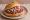 Rindermett: an illustration of beef, onion and pepper on kaiser roll.