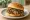 Ròu Jiā Mó Hànbǎo (肉夹馍汉堡): an illustration of pork, beef, cilantro, pepper and more on burger bun.