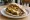 Sabich Oved Style: an illustration of eggplant, egg, hummus, tahini and more on pita.