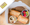 A boxed lunch with a halved baguette sandwich, pasta salad, fruit cup and cookie, the lid carrying an Angelina's label.