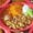 Overhead view of a red oval plate with scrambled eggs and ham, orange rice, refried beans with cheese, sour cream and guacamole.