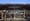 Glass storefront with large MARINWOOD MARKET letters on a dark canopy, sliding doors, shopping carts and patio tables.