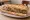 Sandwich à l'Andouillette: an illustration of mustard, butter and pickle on baguette.