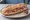 Sandwich Artésien: an illustration of pork and pickle on baguette.