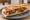 Sandwich aux Grattons: an illustration of pork on baguette.