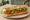 Sandwich aux Légumes: an illustration of lettuce, tomato, cucumber and olive oil on baguette.