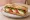 Sandwich Caprese: an illustration of mozzarella, tomato, basil, olive oil and more on baguette.