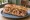Sandwich Cassoulet: an illustration of pork, sausage, beans, onion and more on baguette.