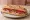 Sandwich Catalan: an illustration of pork, tomato, garlic, olive oil and more on baguette.
