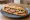 Sandwich Cervelas Alsacien: an illustration of mustard, butter, onion and pickle on baguette.
