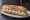 Sandwich Cervelle de Canut: an illustration of onion, scallion, parsley, garlic and more on baguette.