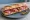 Sandwich Coppa: an illustration of capicola, butter and pickle on baguette.