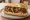 Sándwich de Carrito: an illustration of chorizo, chimichurri and onion on baguette.