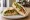 Sándwich de Hummus: an illustration of hummus, cucumber, tomato, lettuce and more on pita.