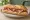 Sándwich de Jamón Crudo: an illustration of prosciutto, butter and cheese on baguette.