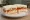 Sándwich de Miga Olímpico: an illustration of ham, cheese, egg, tomato and more on white bread.