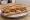 Sandwich Dijonnais: an illustration of ham, beef, butter and pickle on baguette.