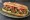 Sandwich Falafel: an illustration of falafel, tahini, lettuce, tomato and more on baguette.