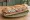 Sandwich Lyonnais: an illustration of onion, scallion, parsley and garlic on baguette.