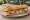 Sandwich Marché: an illustration of ham, gruyère, butter, pickle and more on baguette.