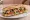 Sandwich Méditerranéen: an illustration of tuna, tomato, basil, olive oil and more on baguette.