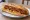 Sandwich Merguez: an illustration of potato, harissa, onion, paprika and more on baguette.
