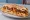 Sandwich Merguez-Frites: an illustration of potato, harissa, béchamel and onion on baguette.