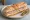 Sandwich Pâté Hénaff: an illustration of pork, butter, pickle and pepper on baguette.