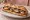 Sandwich Provençal: an illustration of tomato, olives, anchovy, egg and more on baguette.