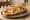 Sandwich Raclette Baguette: an illustration of gruyère, ham, pickle, butter and more on baguette.