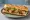 Sandwich Rillons: an illustration of pork belly, mustard, pickle and pepper on baguette.