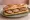 Sandwich Saucisse de Montbéliard: an illustration of butter, mustard, cumin and pickle on baguette.